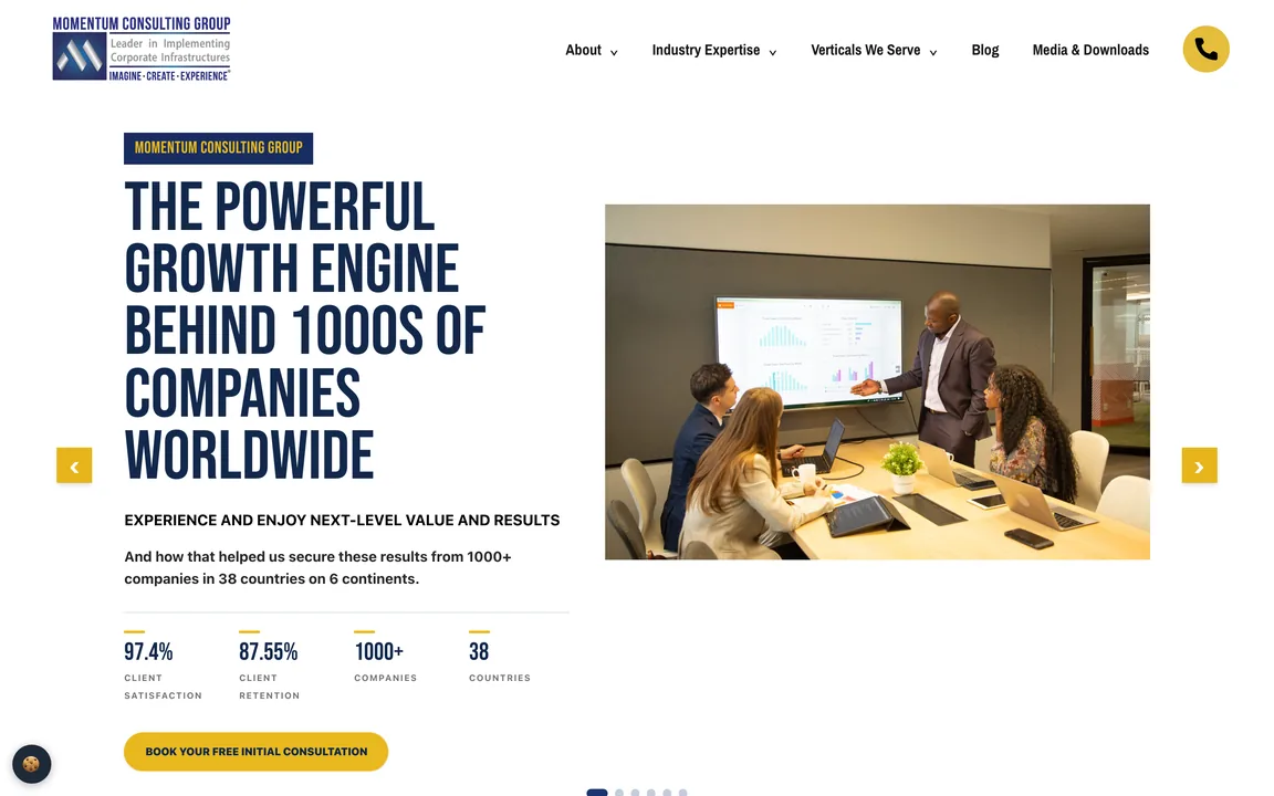 Momentum Consulting Group homepage with the headline The Powerful Growth Engine Behind 1000s of Companies Worldwide, a photo of a team meeting, carousel arrows and a Book Your Free Initial Consultation button.