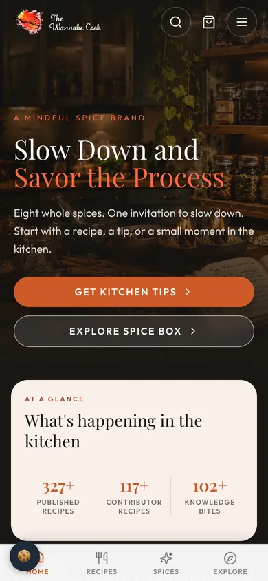 The Wannabe Cook homepage on a phone with search, cart and menu buttons, the headline, two buttons, an At a Glance panel and a bottom tab bar.